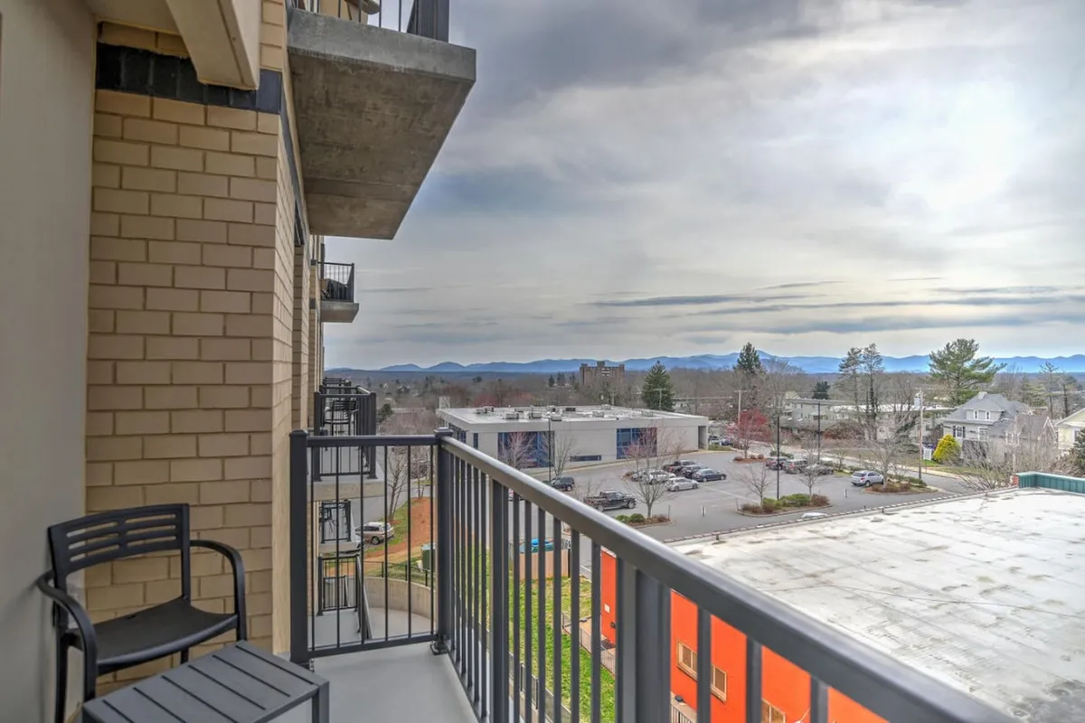 An exterior perspective from the balcony, showing its railing and sweeping mountain and city views. The peaceful atmosphere invites moments of morning coffee or evening relaxation while overlooking the urban landscape.